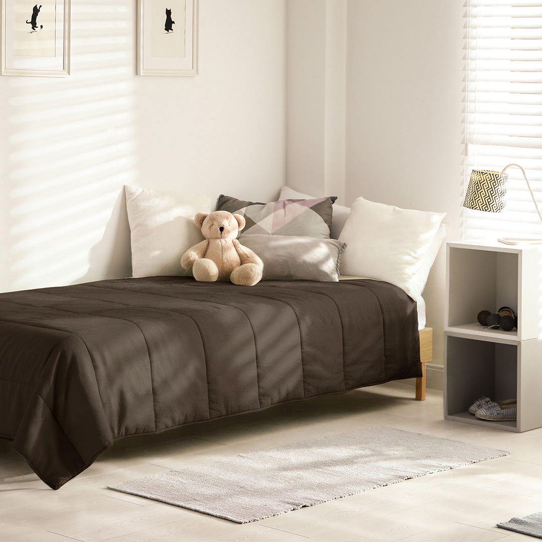 Mousseline Chocola dekbed op een kinderbed met knuffelbeer