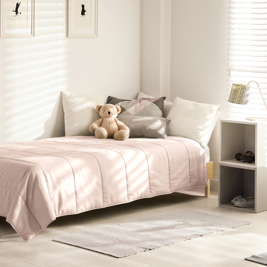 Mousseline Zachtroze dekbed op een kinderbed met knuffelbeer